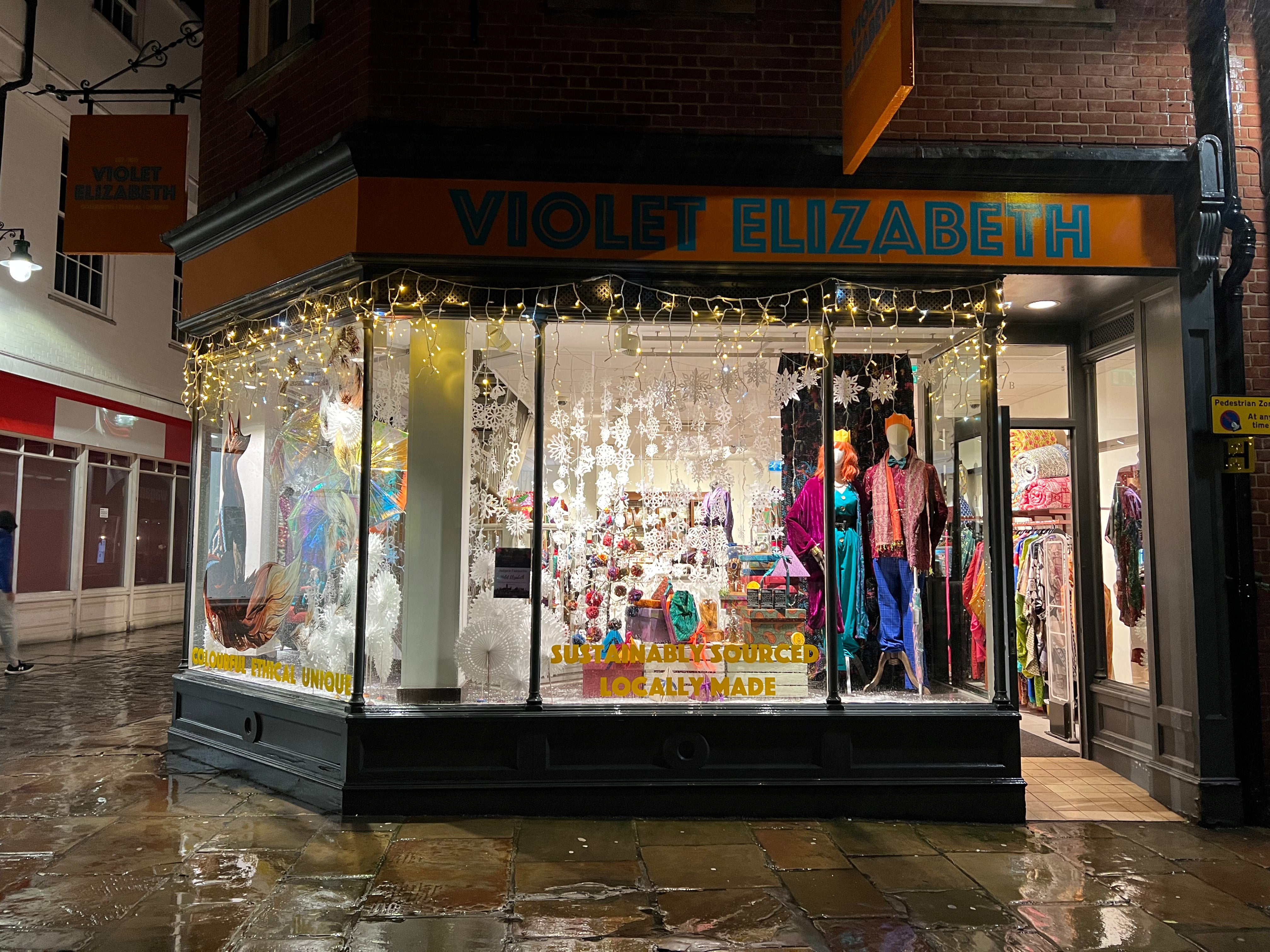 Violet Elizabeth store front with mannequins and clothing displayed in a glass case.